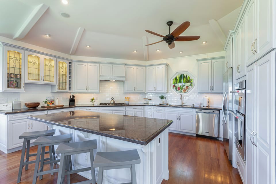 Spacious and well-lit kitchen equipped with stainless steel appliances, perfect for hosting and gathering.