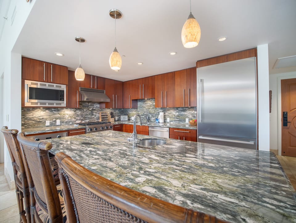 Cook in a luxurious kitchen featuring high-end appliances and beautiful granite countertops, ideal for preparing family meals during your stay.