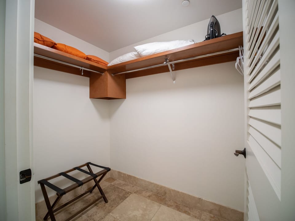 Keep your belongings organized in this spacious walk-in closet, complete with extra pillows and an iron for your convenience.