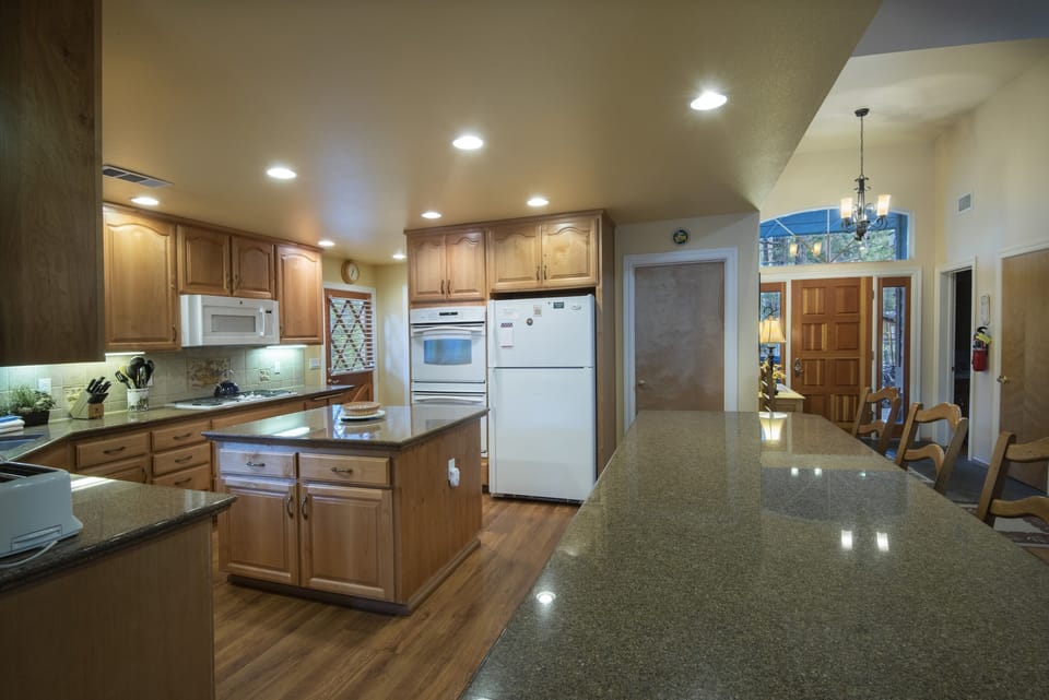 Large spacious kitchen with granite counter top, island and double ovens