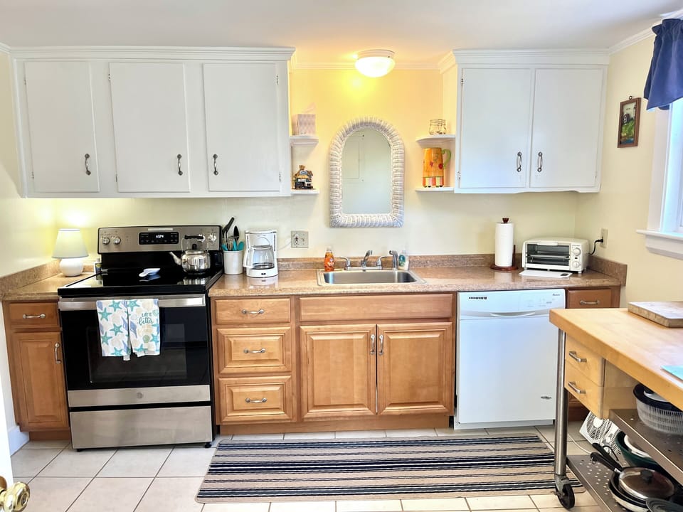 Kitchen with NEW stove, Dishwashing Machine and ceramic tile floor.