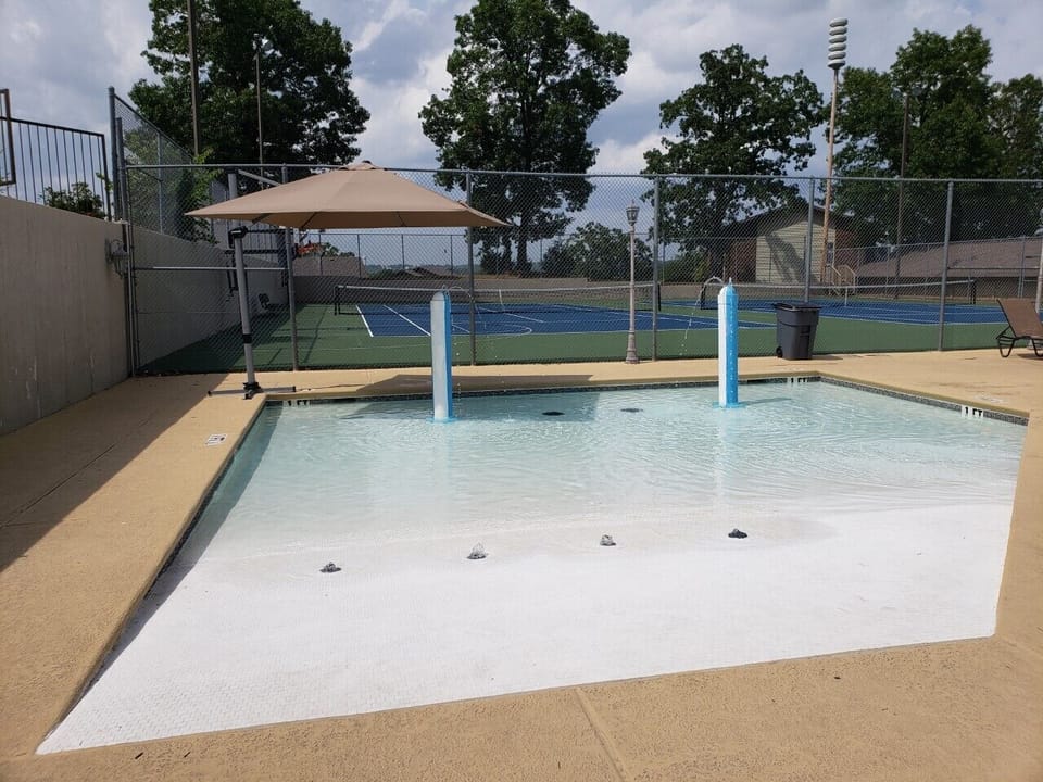 Baby pool has umbrella for shade.