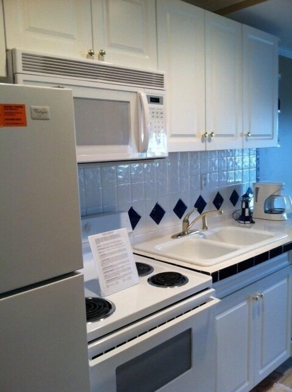 view of kitchen with full size refrigerator, oven, microwave