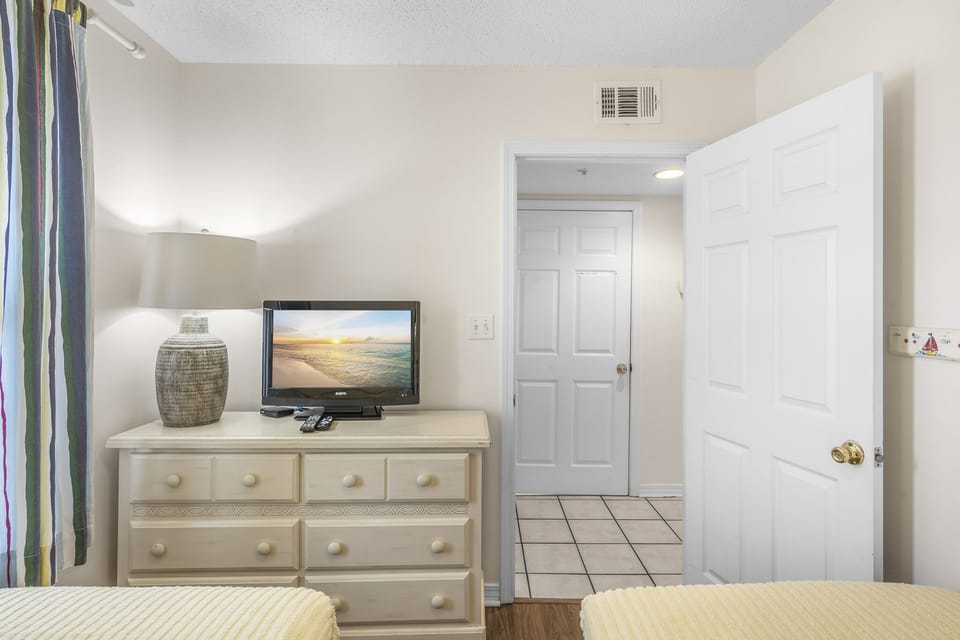 A comfortable bedroom with a smart TV and ample storage.