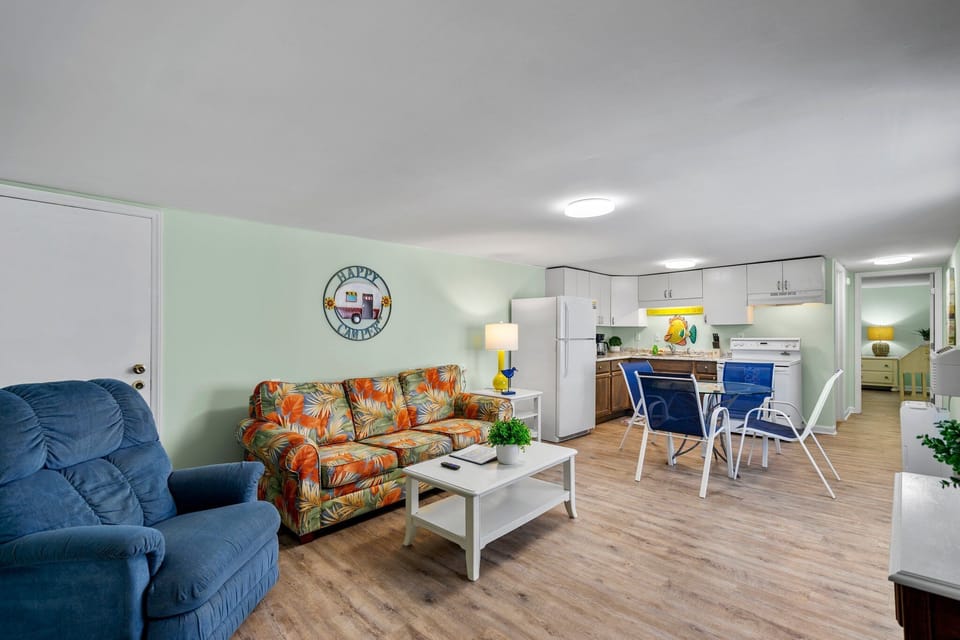 Relax in your bright, open-concept space with tropical-print sofa, full kitchen, and cheerful coastal decor that makes you feel instantly at home.