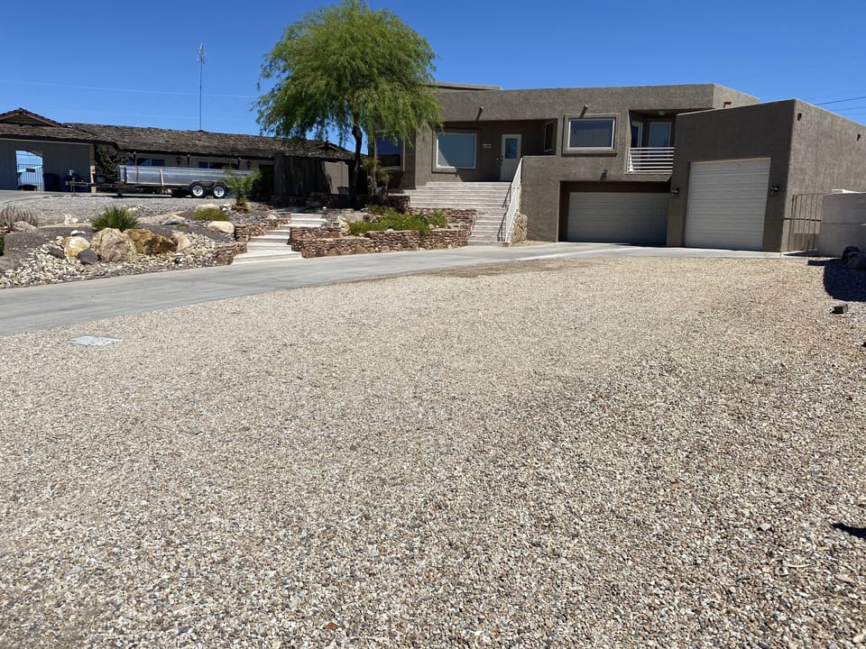Huge driveway with gravel for parking all the toys. 40'x80'.