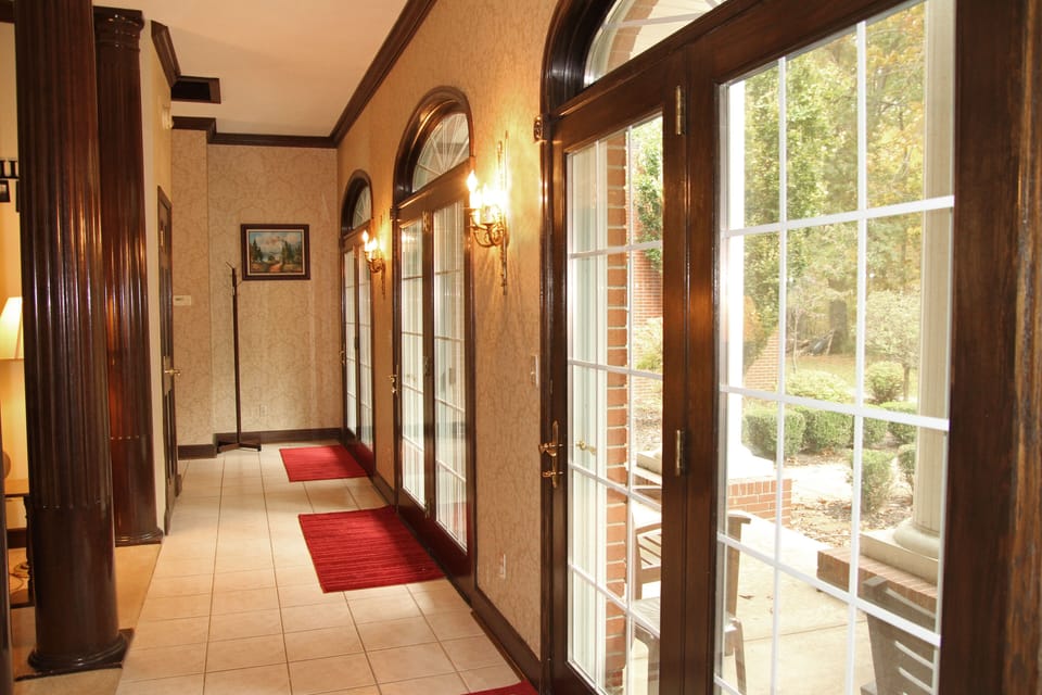 Gallery with doors to the back porch, English gardens, and bonfire pit.