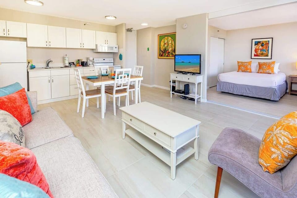 Bright open-plan living area with a fully equipped kitchen and adjacent bedroom