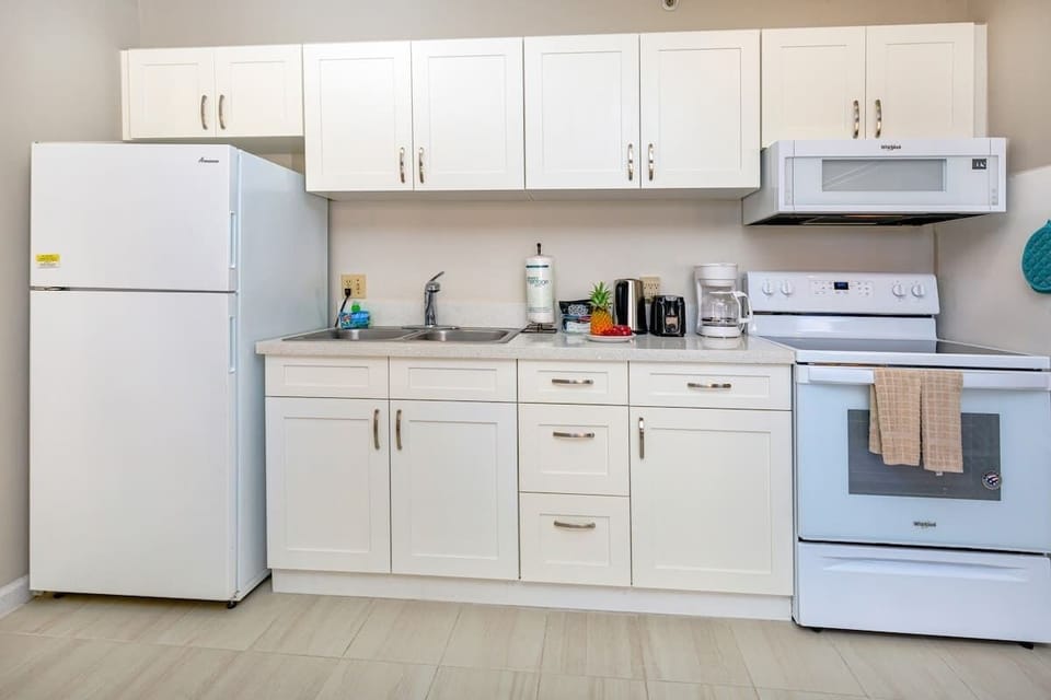 Modern kitchen with white cabinetry and essential appliances for convenient cooking.