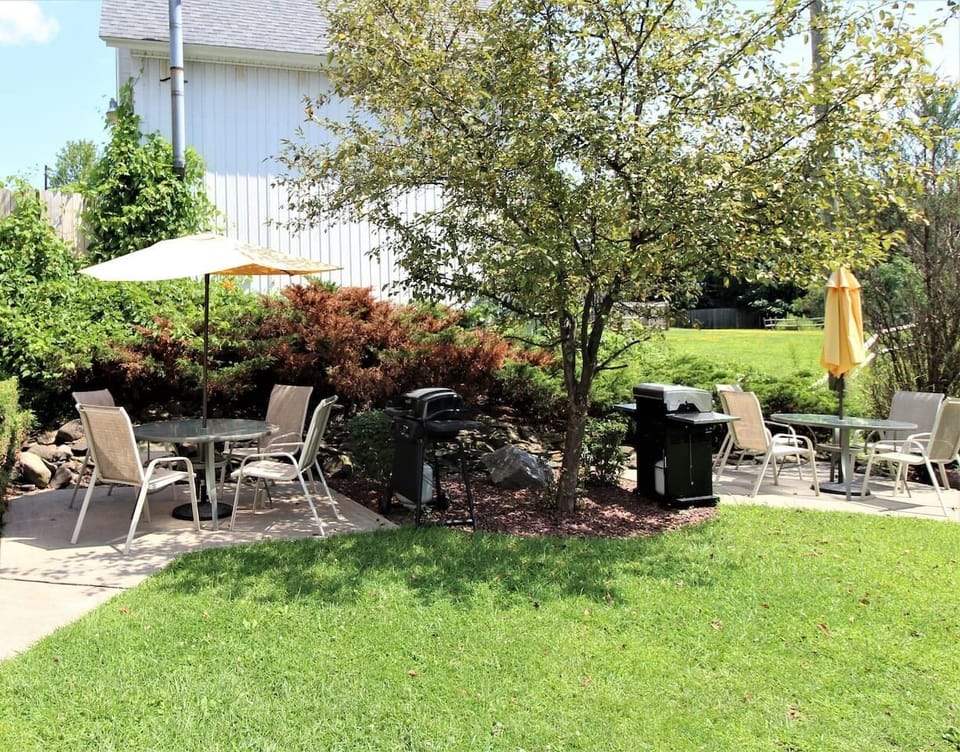 Backyard BBQ area with gas grills and patio dining sets