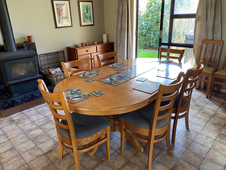 Dining area opening onto deck with log burner for winter