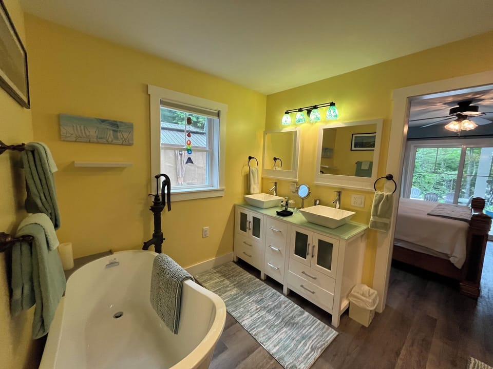 View of master bath tub, vanity looking out to gazebo, and view through bedroom.