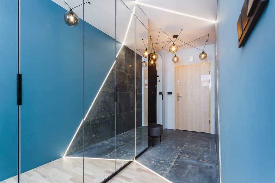 A hallway with a sleek design, featuring black and white tones, glass doors, and modern lighting.