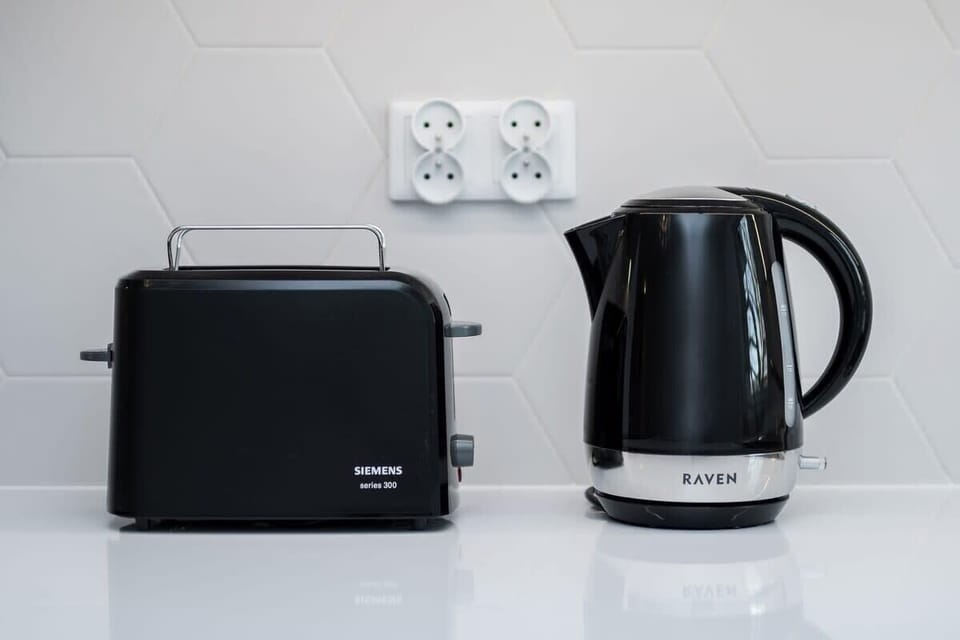 Close-up of black toaster and in matching colour electric kettle.