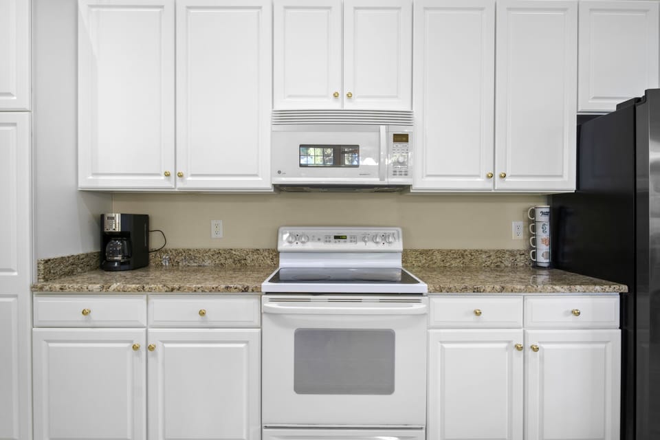 69 Willow Oak Ave - Kitchen Detail and Cabinetry - The kitchen's linear layout maximizes efficiency, offering generous counter space for meal preparation. Recessed lighting and high ceilings make the area feel spacious and well-lit, making it a functional hub for the home.