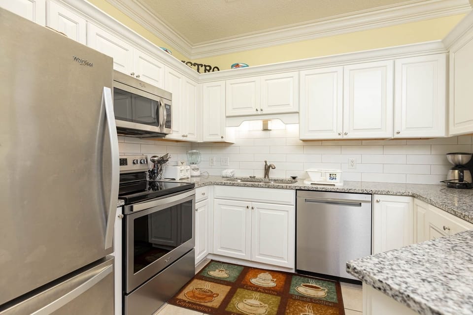 Prepare meals in this elegant kitchen, featuring stainless appliances, granite countertops, and cheerful decor
