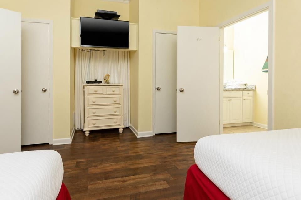 Cozy guest bedroom featuring double beds, a TV, and easy access to the bathroom area for your convenience