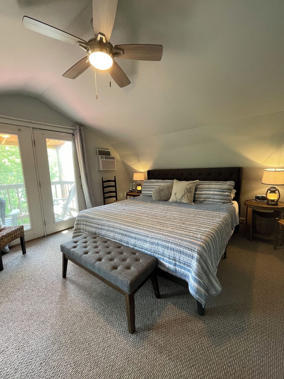 King bed in master with view of lake & balcony with seating.
