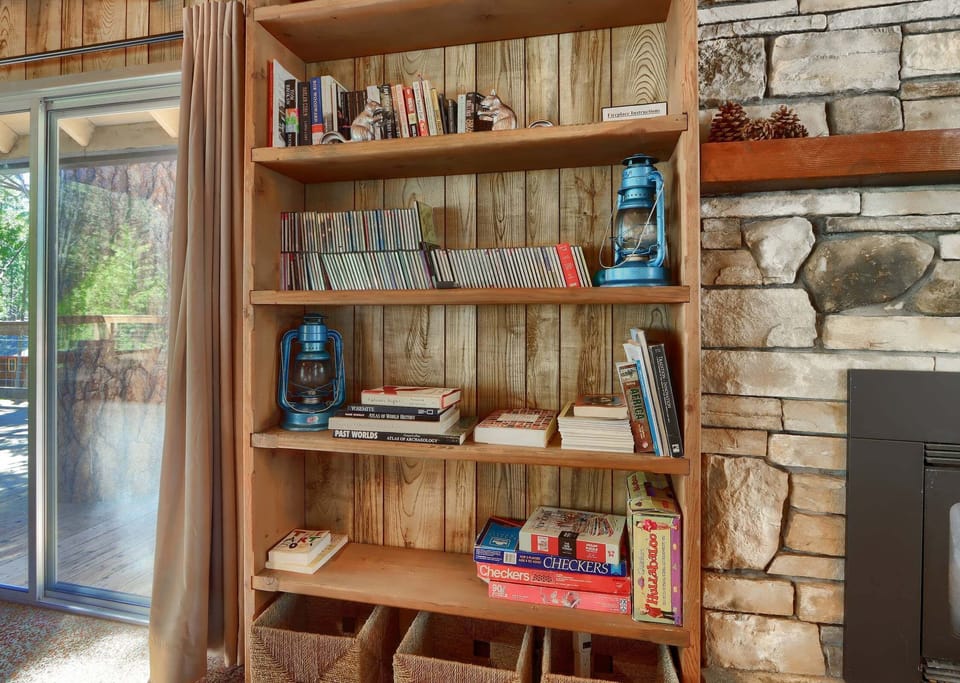 Bookcase in the living room with a sliding glass door to the deck