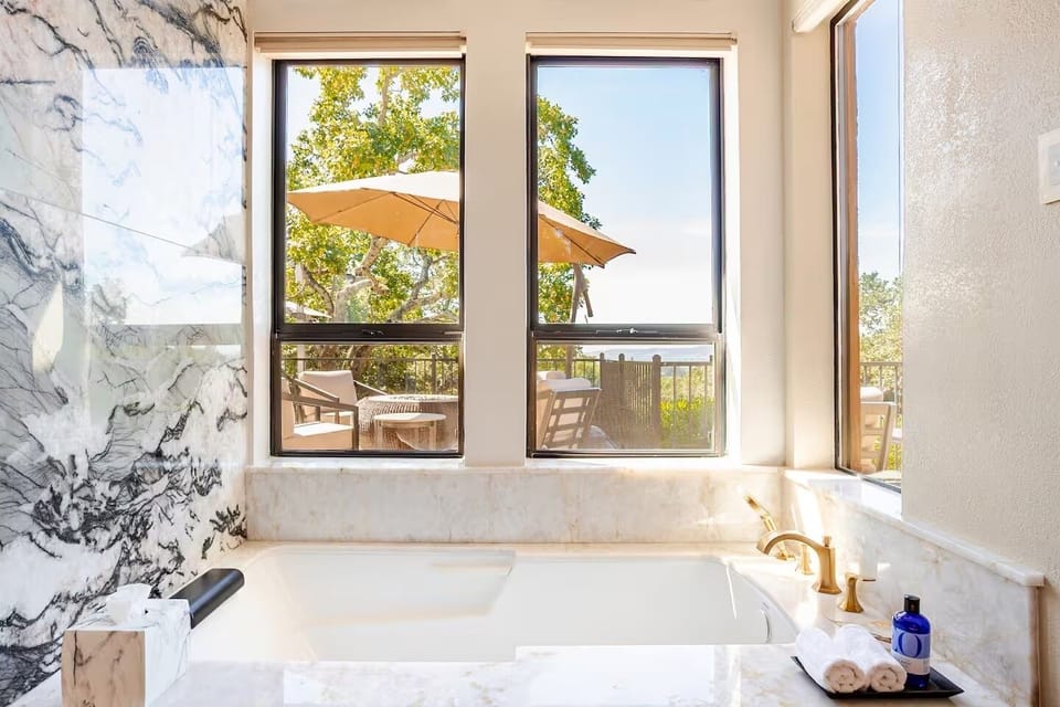 Primary bath with  sunken jacuzzi tub with quartz accent wall.