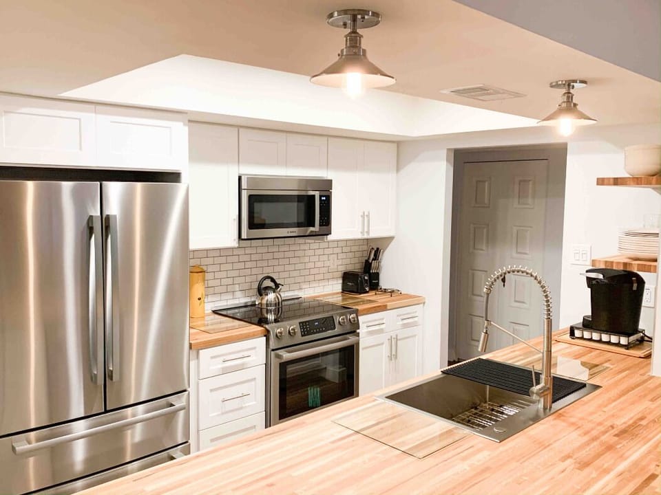 Kitchen with updates appliances and butcher block counters.