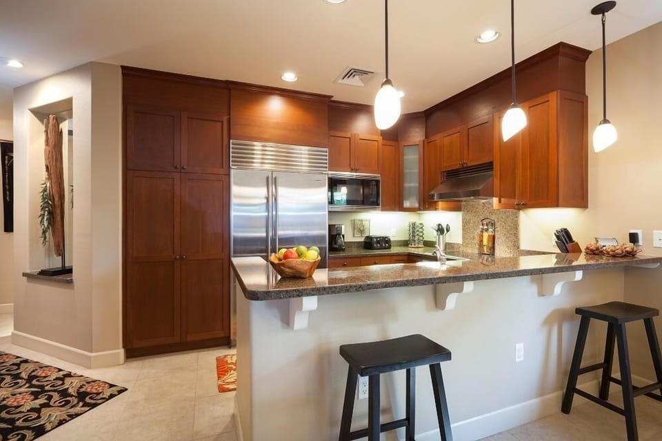 Full kitchen with stainless steel appliances, granite countertops, and breakfast bar