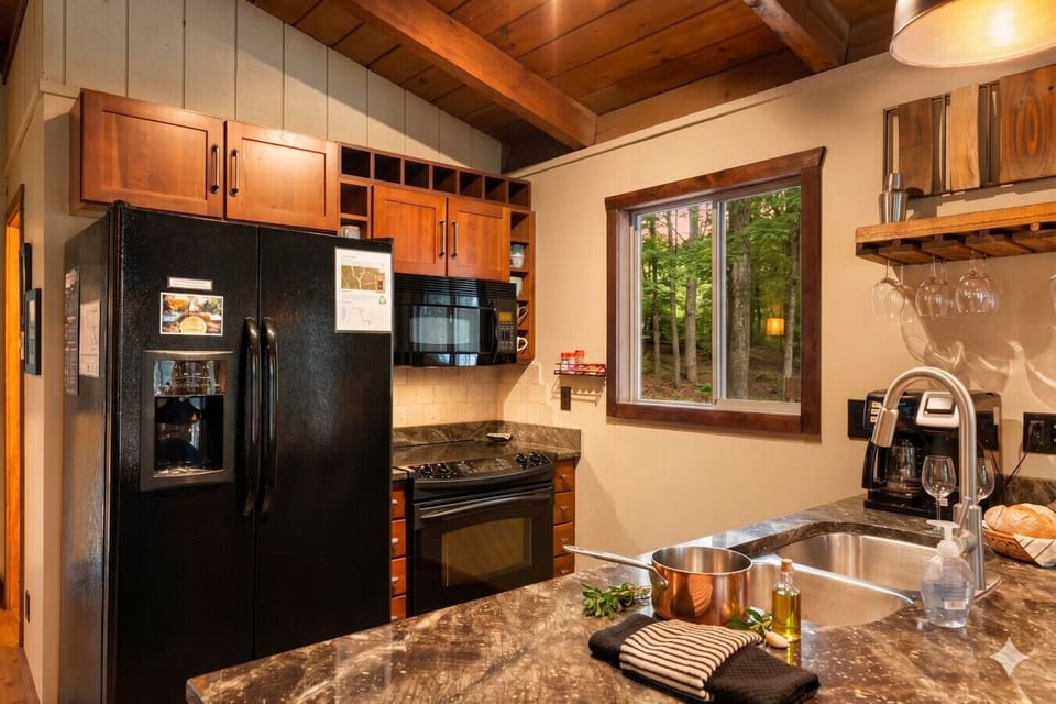 Cozy, fully stocked kitchen with forest views — perfect for family meals after skiing Schuss Mountain or exploring Bellaire & Torch Lake.