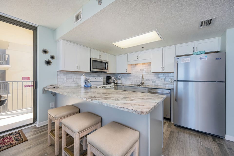 Soft bar stools invite you to chat and snack while fresh gulf breezes drift in from the balcony door