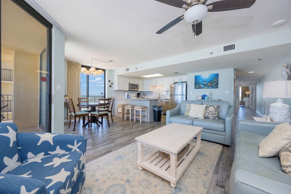 In the living room, you sink into cozy seating and listen to the gentle hum of the ceiling fan above