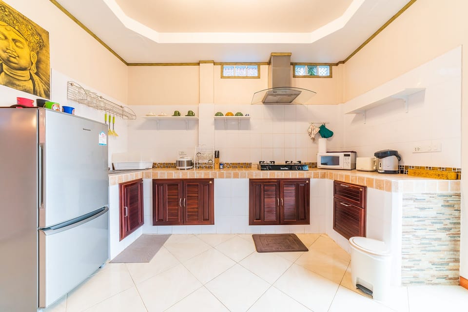 1st floor's fully-equipped kitchen with fridge, microwave, stove and utensils
