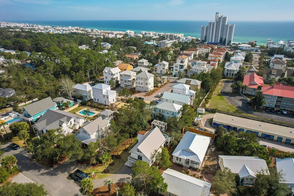 Aerial view showcasing the coastal community with charming beach homes nestled among trees, just minutes from pristine Gulf waters.