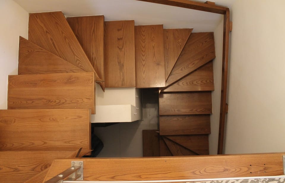 Floating wood spiral staircase leading to penthouse level.
