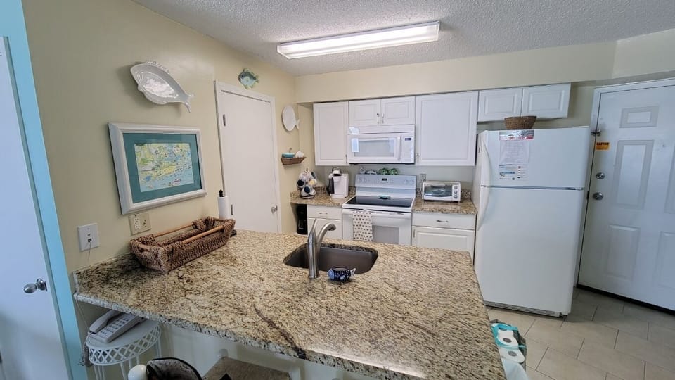 Full kitchen with two eating spaces and chairs at the counter