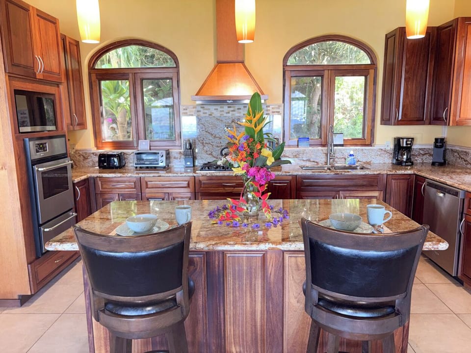 The kitchen island includes a couple of bar stools, a perfect spot to plan your day