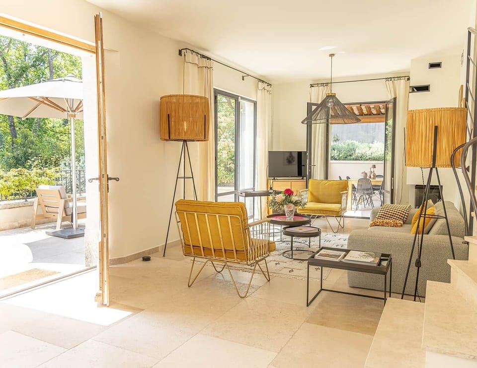 Salon vue ensemble fauteuil ocre terrasse jardin bastide du couchant saint remy de provence