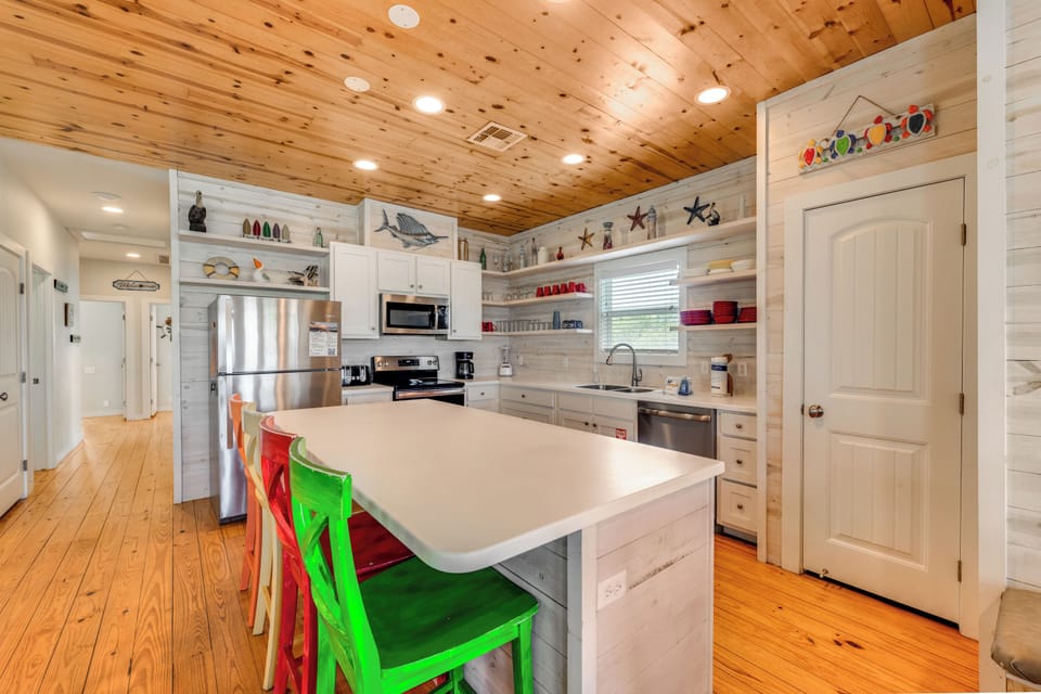 Cook together in this bright, fully-equipped kitchen with charming wood ceilings and colorful island seating.