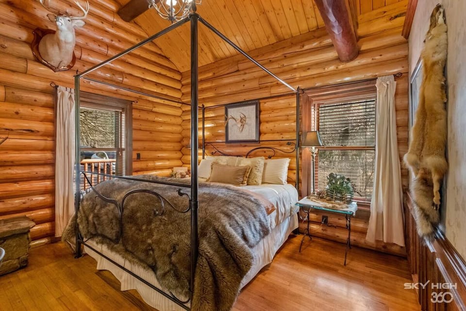 This king sized wrought iron bed is adorned with fur and linen bedding.