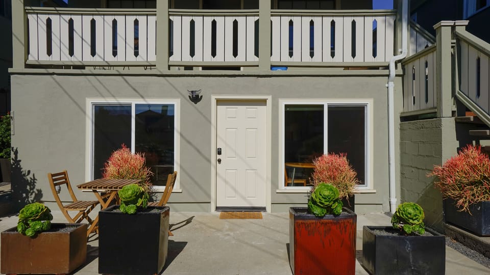 View of the front entrance with parking and patio.