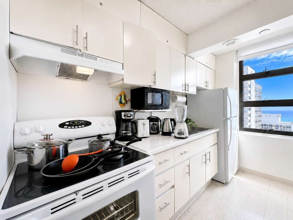 Whip up delicious home-cooked meals in this fully equipped, sunlit kitchen featuring ample counter space and stunning ocean views