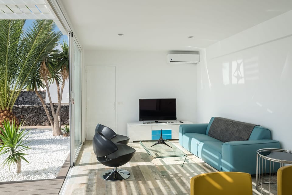 Relaxation space: bright living room with comfortable sofas and direct access to the pool area.