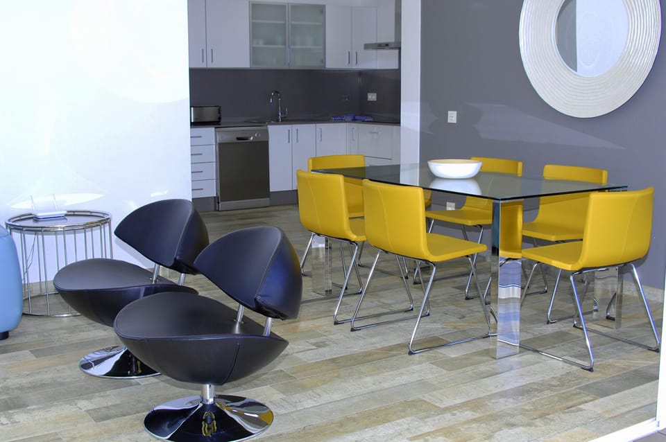 Vibrant design: modern dining area with a mix of yellow and black designer chairs.