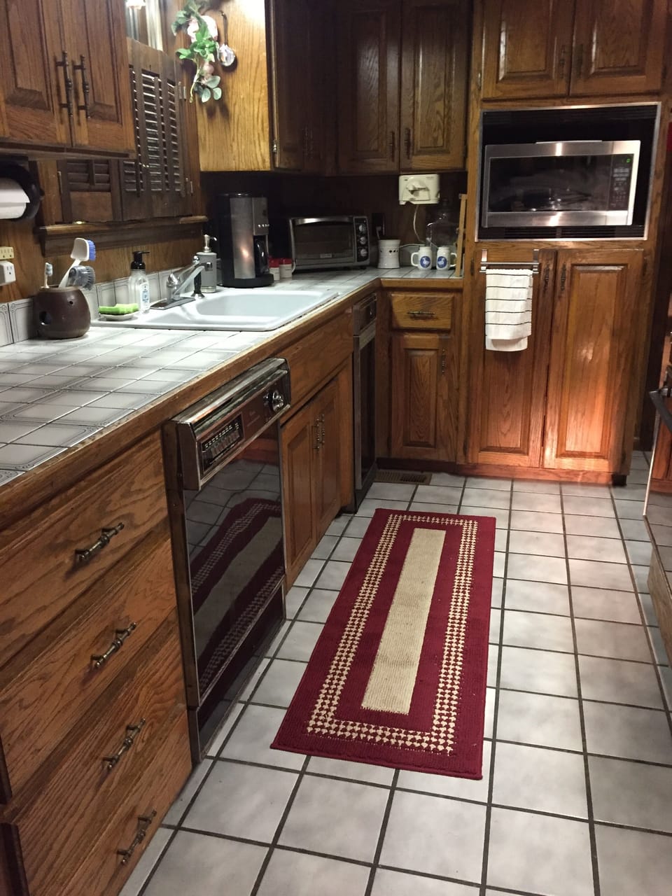 Kitchen view of large counter, double sink, dishwasher and microwave