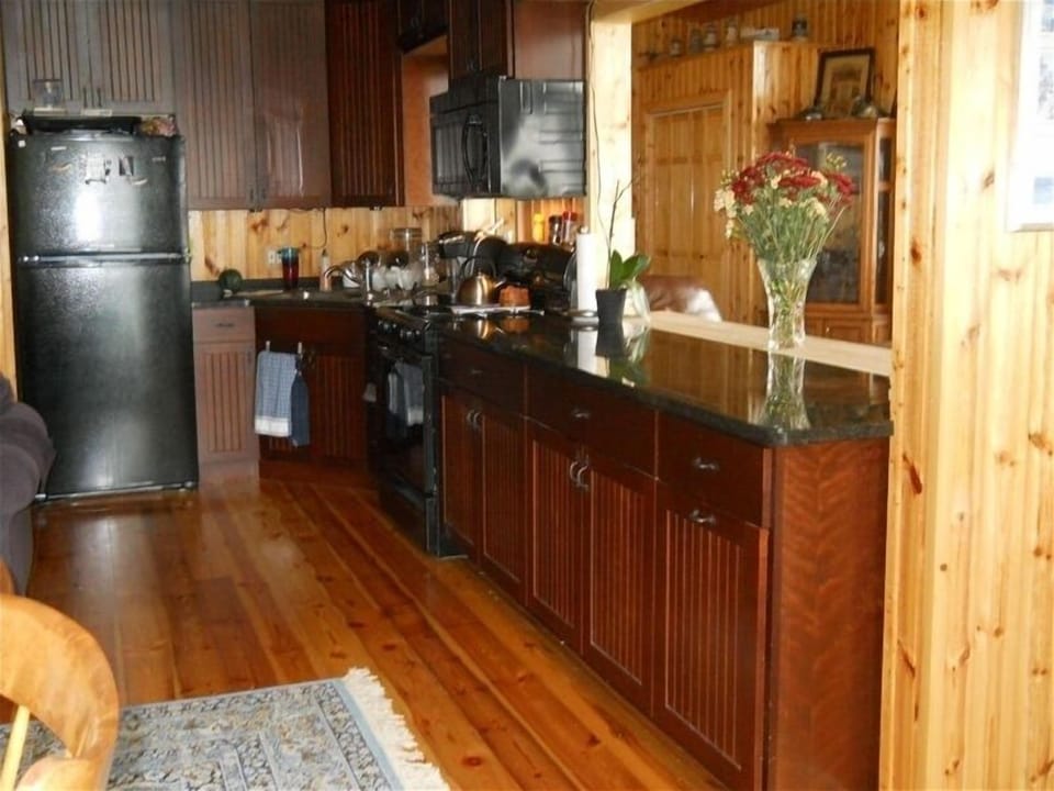 Modern kitchen with stove, microwave, refrigerator, granite countertop
