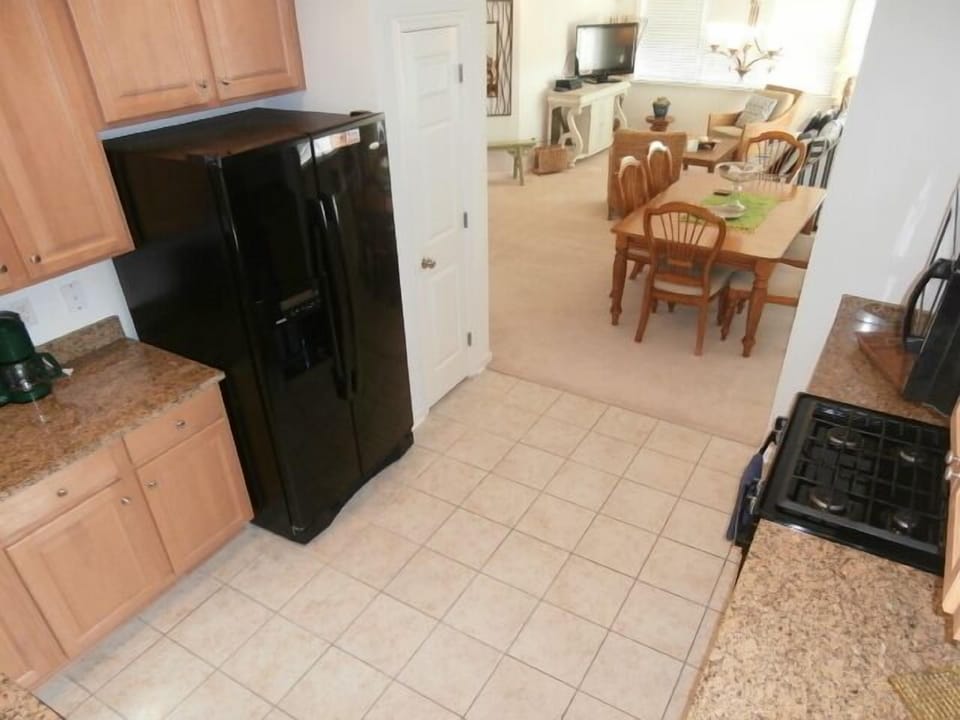 Kitchen w/ Granite, Gas Stove, Sleek Black Appliances, Tile Flooring and Plenty of Counter Space.