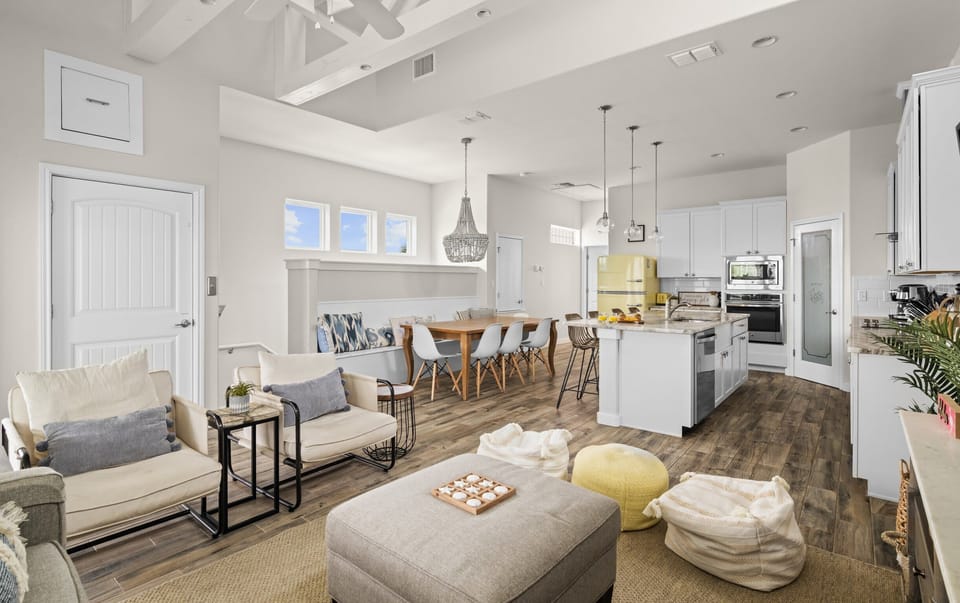 Open Floor Plan — Cream Sofa & Chairs, Gray Ottoman, Jute Rug, Yellow Pouf & Beaded Chandelier