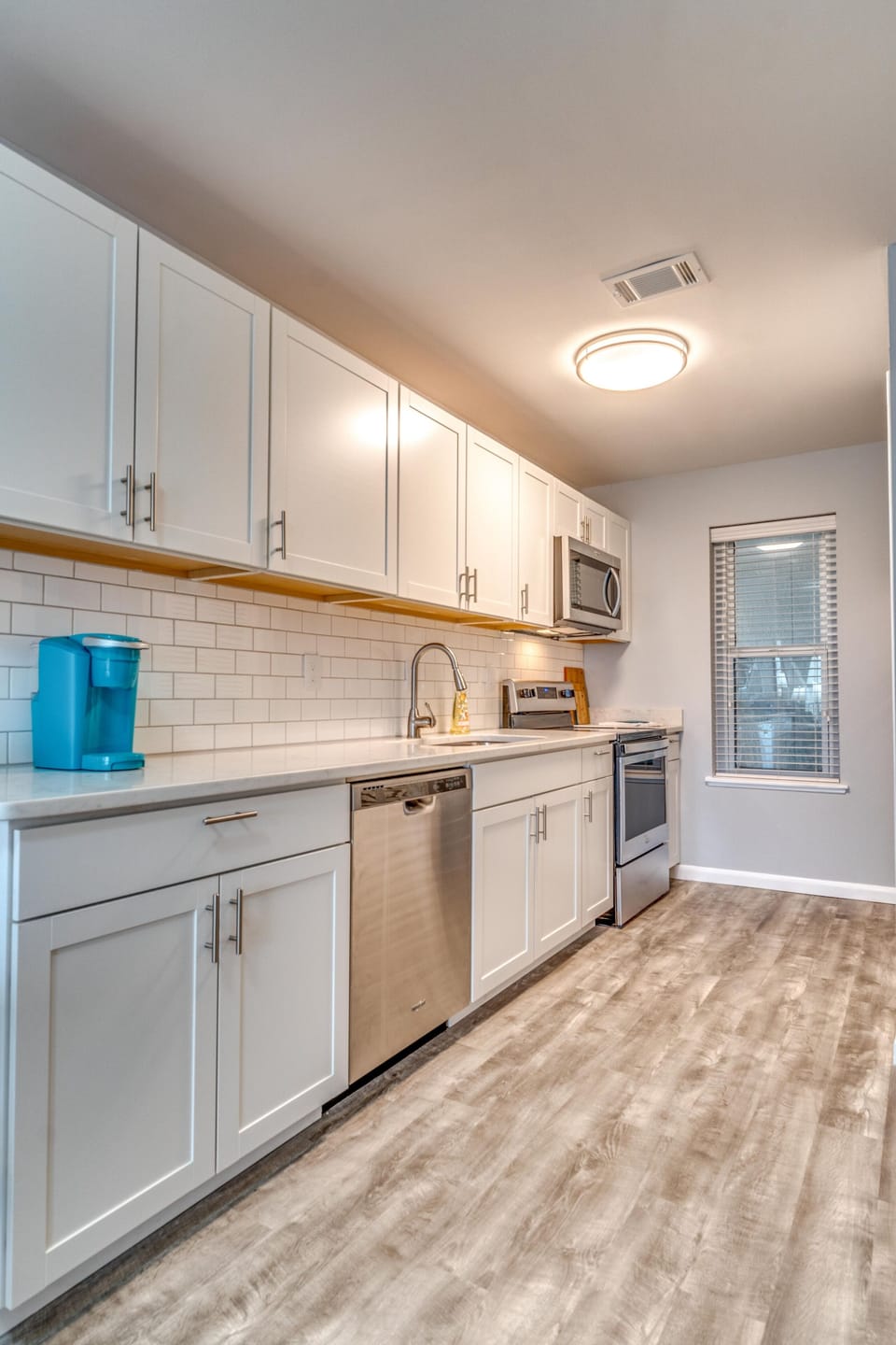 Stocked kitchen with quartz countertops, stainless steel appliances, and Keurig 
