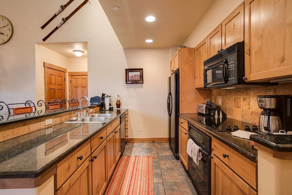 Your fully-equipped kitchen features granite countertops, stainless appliances, and warm wood cabinets—perfect for cooking memorable meals during your mountain getaway.