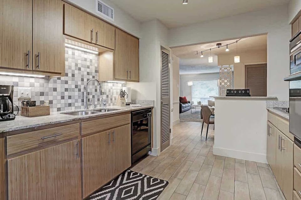 Fully Equipped Kitchen, Bamboo accented cabinets and ceramic tile floors and backsplash. All Black appliances and over counter lighting.
