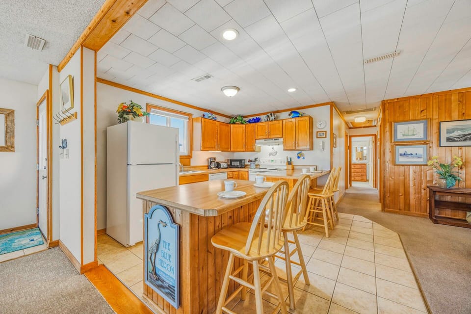 Your fully equipped kitchen features warm wood cabinets, a breakfast bar with seating for four, and everything you need to prepare meals during your stay.