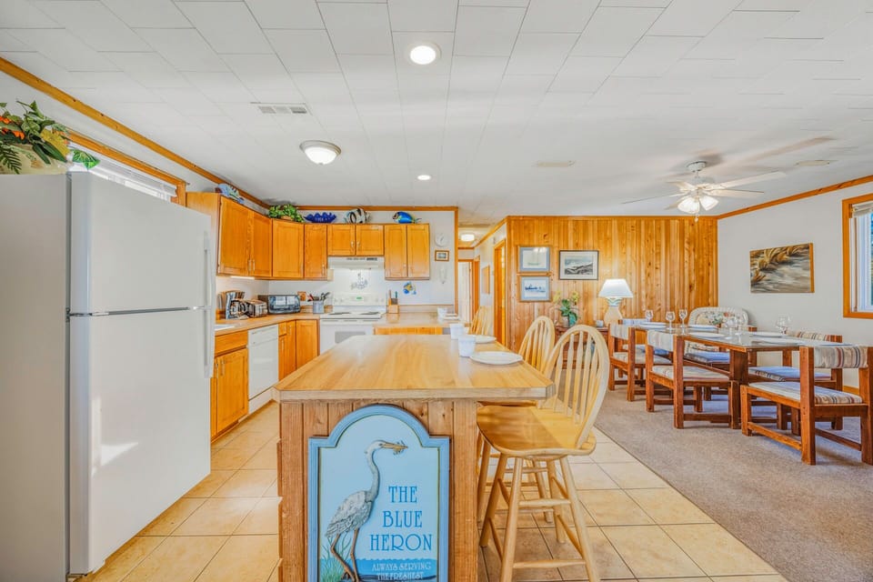 Gather around the spacious kitchen island where warm wood tones create the perfect atmosphere for cooking together and sharing meals.